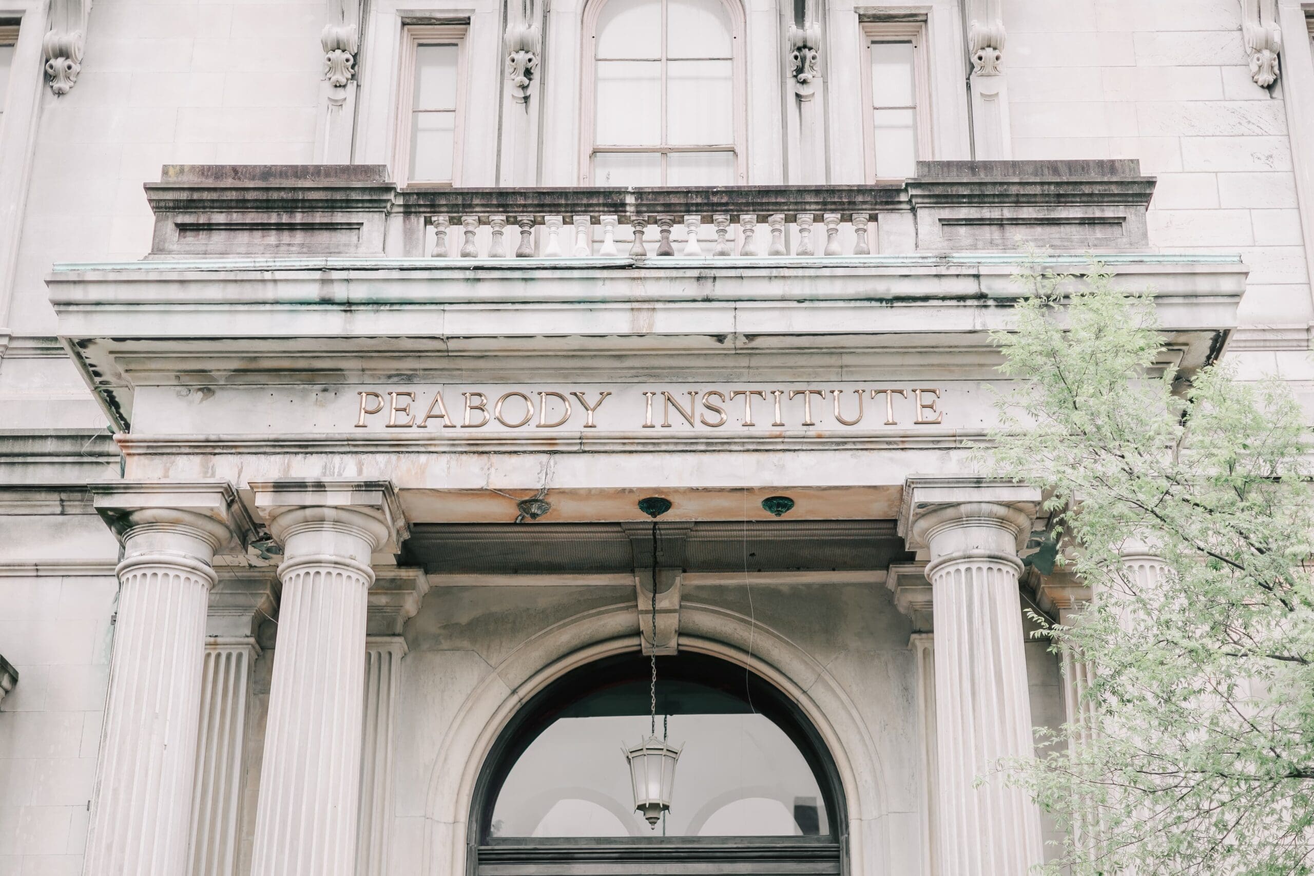 A weathered, white stone building with the words "Peabody Institute" written on it, evoking a sense of history and importance.