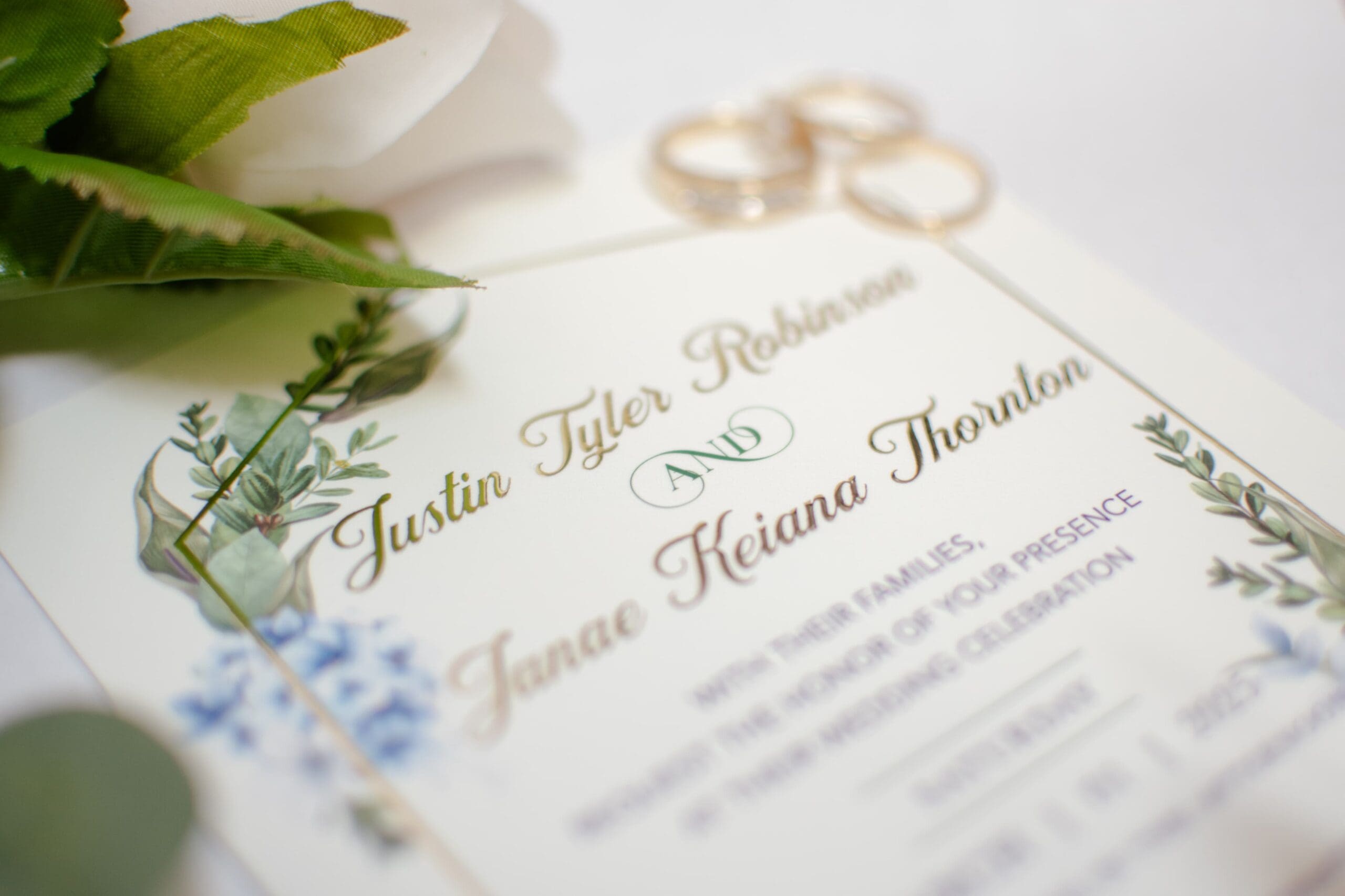 A close-up of an elegant wedding invitation decorated with delicate floral illustrations. The card's soft colors convey a romantic and joyful tone.