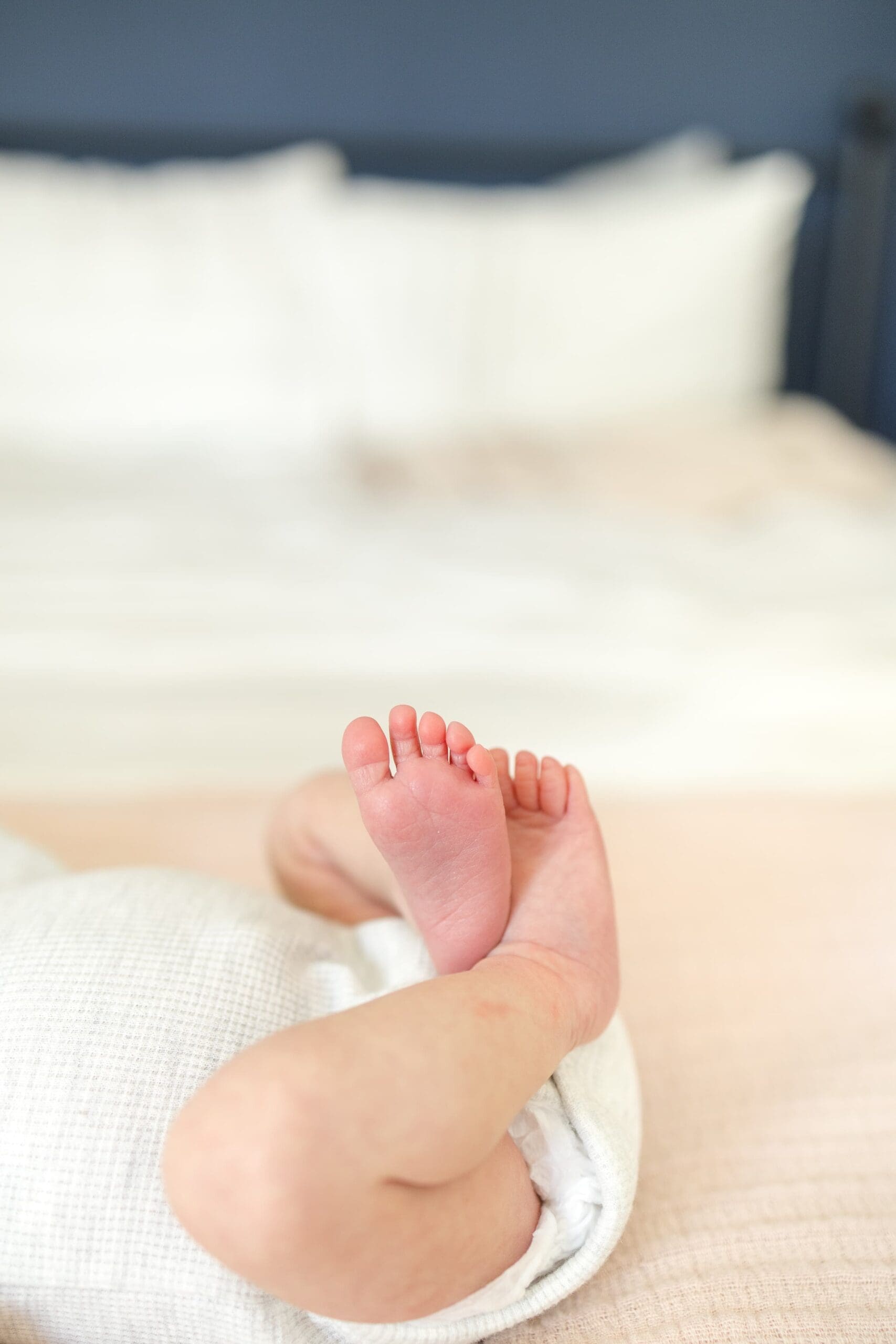 baby feet crossed together on a bed