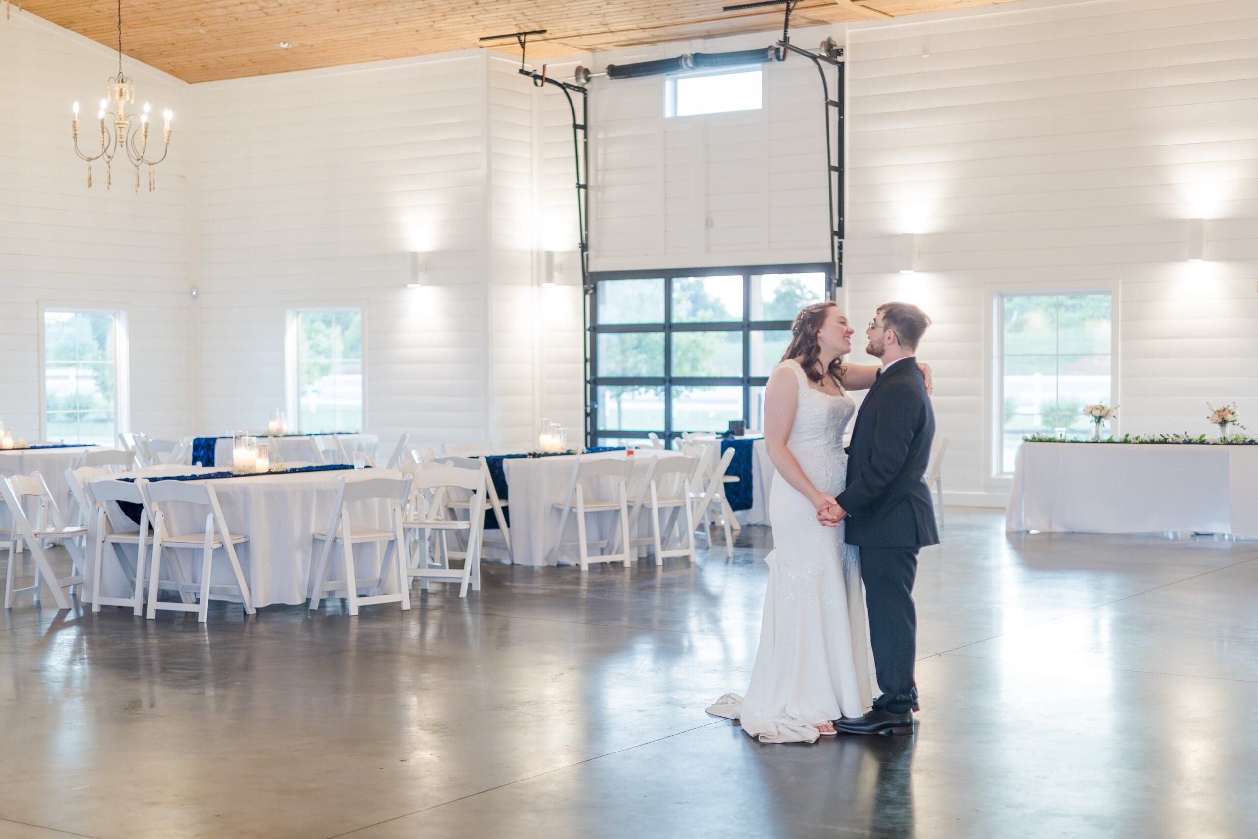 bride in white and groom in black share one last dance on the dance floor privately while no one is around.