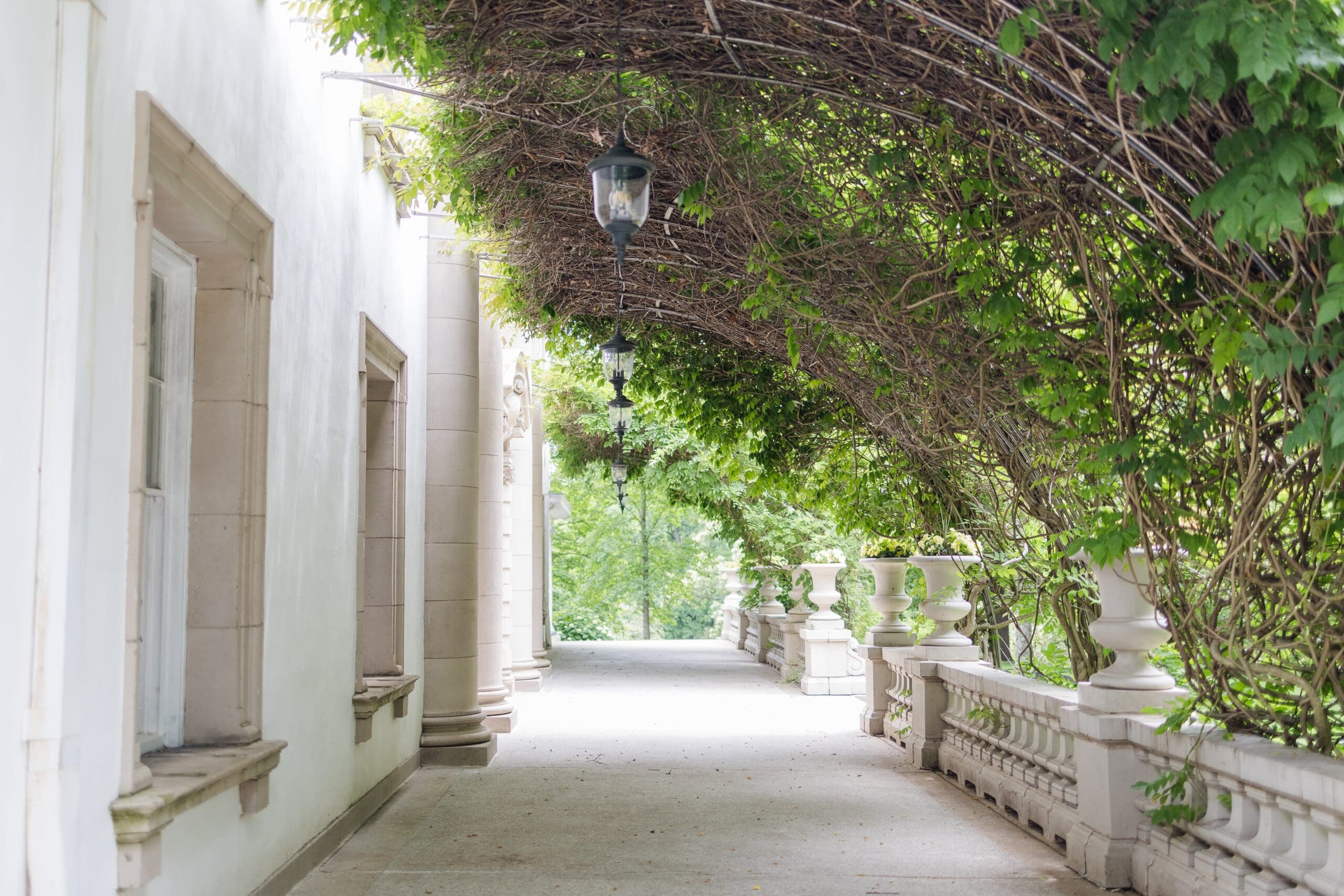 Wisteria-covered walls enclose a large white porch