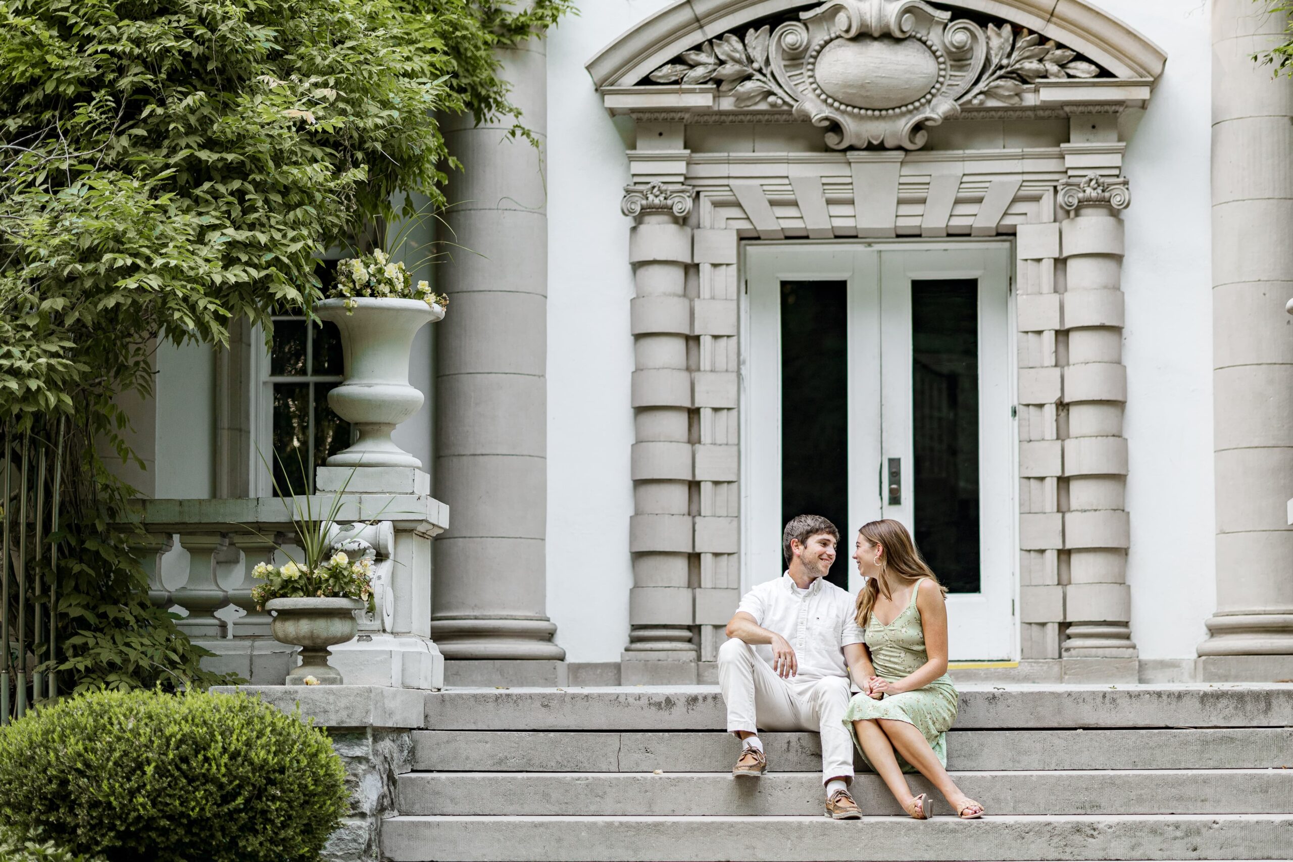 Couple sitting on stairs in front of the Liriodendron Mansion in Bel Air, MD