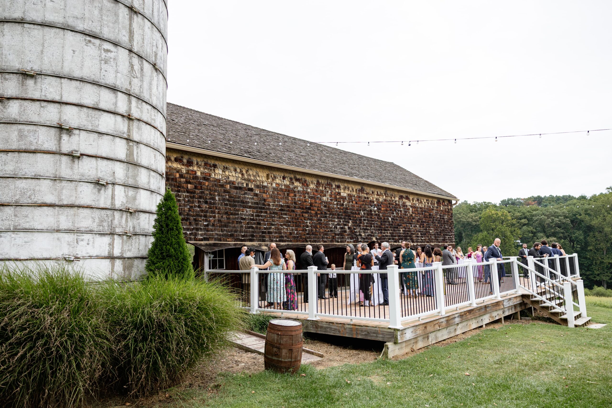 barn wedding venue cocktail hour next to big silo.